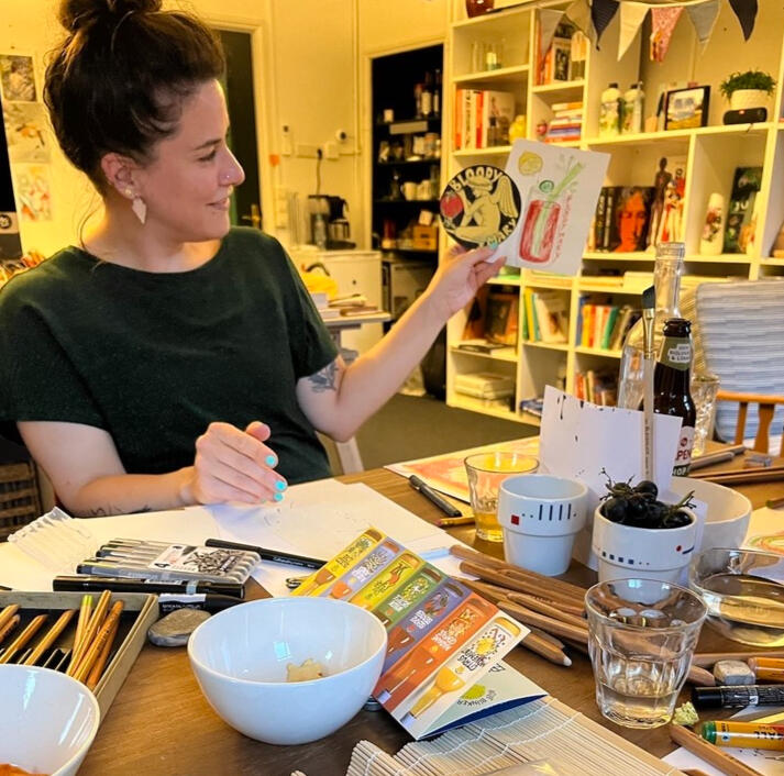 Caro laat haar tekening zien bij Drink & Draw